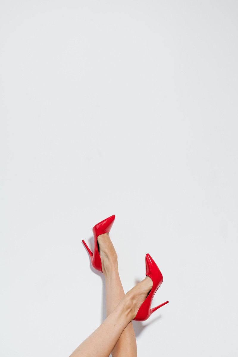 Red patent pumps, worn, against white.