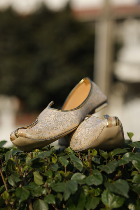 Gold brocade mojaris with curled toes.