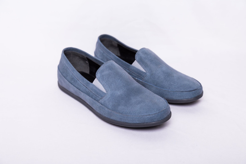 Blue suede slip-on shoes on white.